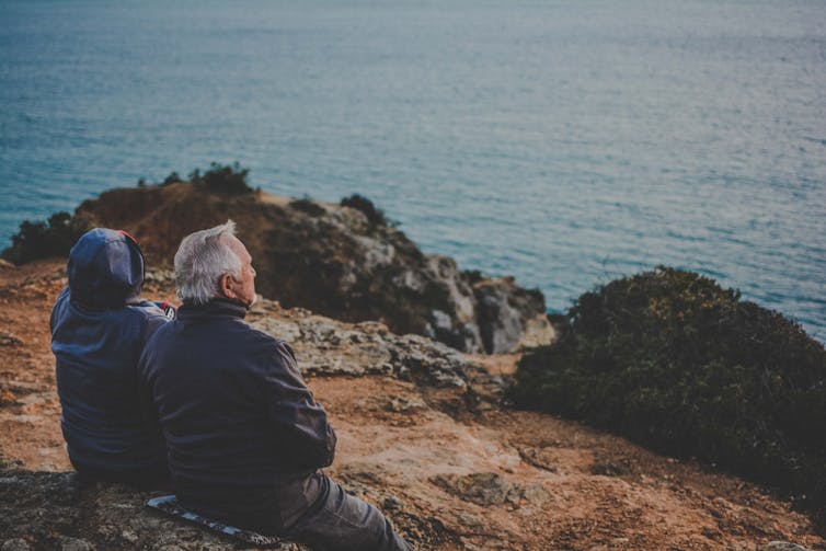 Older people look out over an ocean