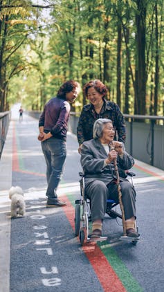 Woman pushes mother in a wheelchair