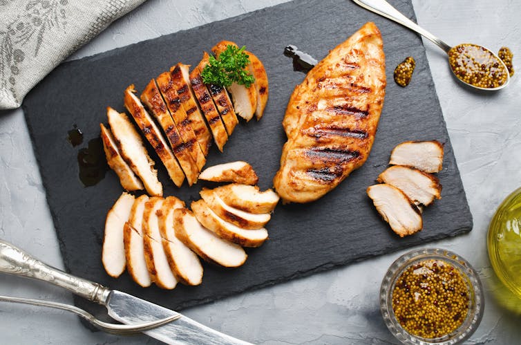 Grilled chicken fillets on a slate plate.