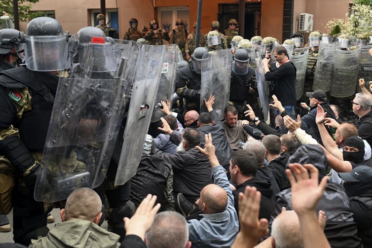 Ethnic Serbs sit in front of a barbed wire barrier defended by Nato KFOR peacekepeers on May 29 2023.