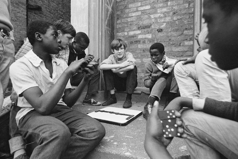 A group of teenage kids sitting outside in a playground talking.