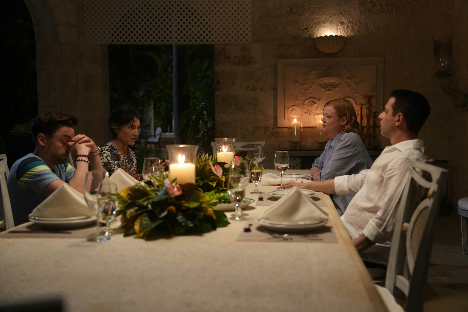 The Roy siblings sit around a dinner table with their mother, Caroline.