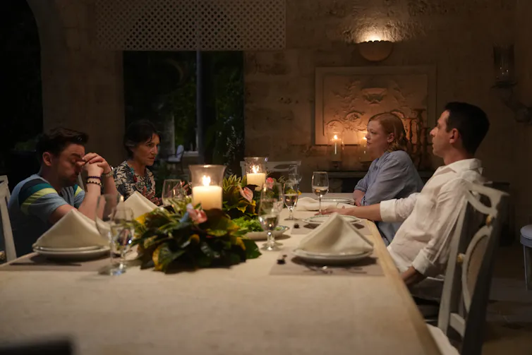 The Roy siblings sit around a dinner table with their mother, Caroline.