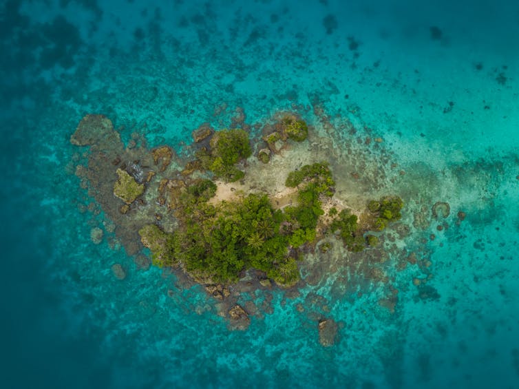 An aerial view of an island surrounded by topical water