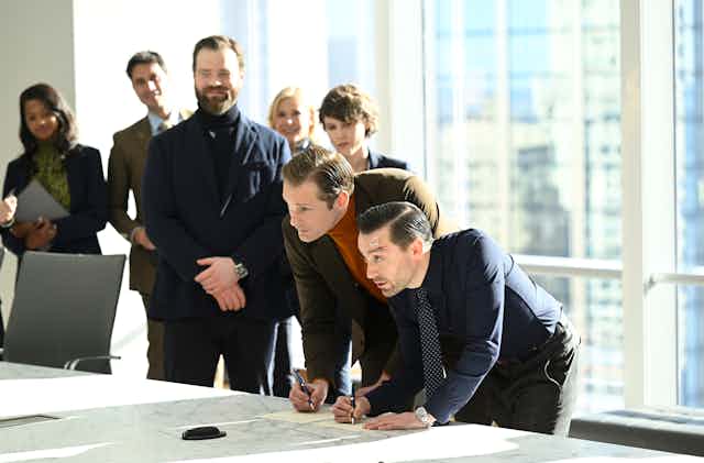 Characters from Succession signing a deal