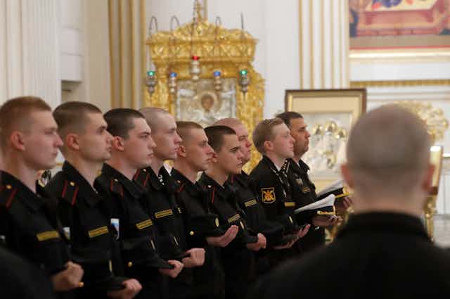 Russian marine conscripts stand in a line in St Petersburg cathedral.