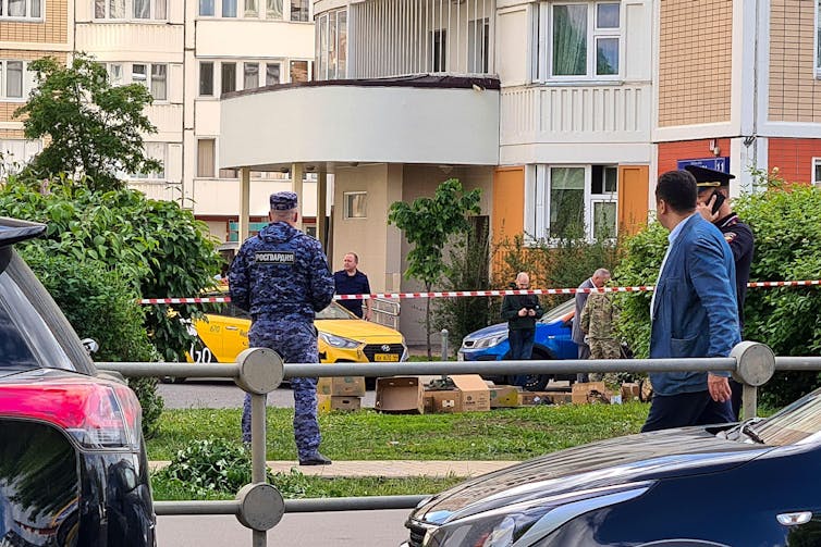 Russian police guard remnants of a drone which reportedly hit a Moscow apartment building on May 30.