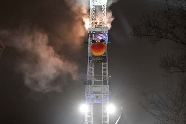 A huge peach labeled '2023' descends a tower, Times Square-style