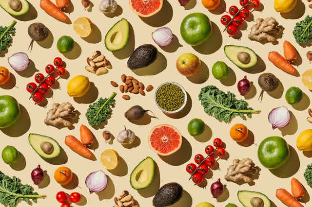 Fruits and vegetables arrayed against a beige background