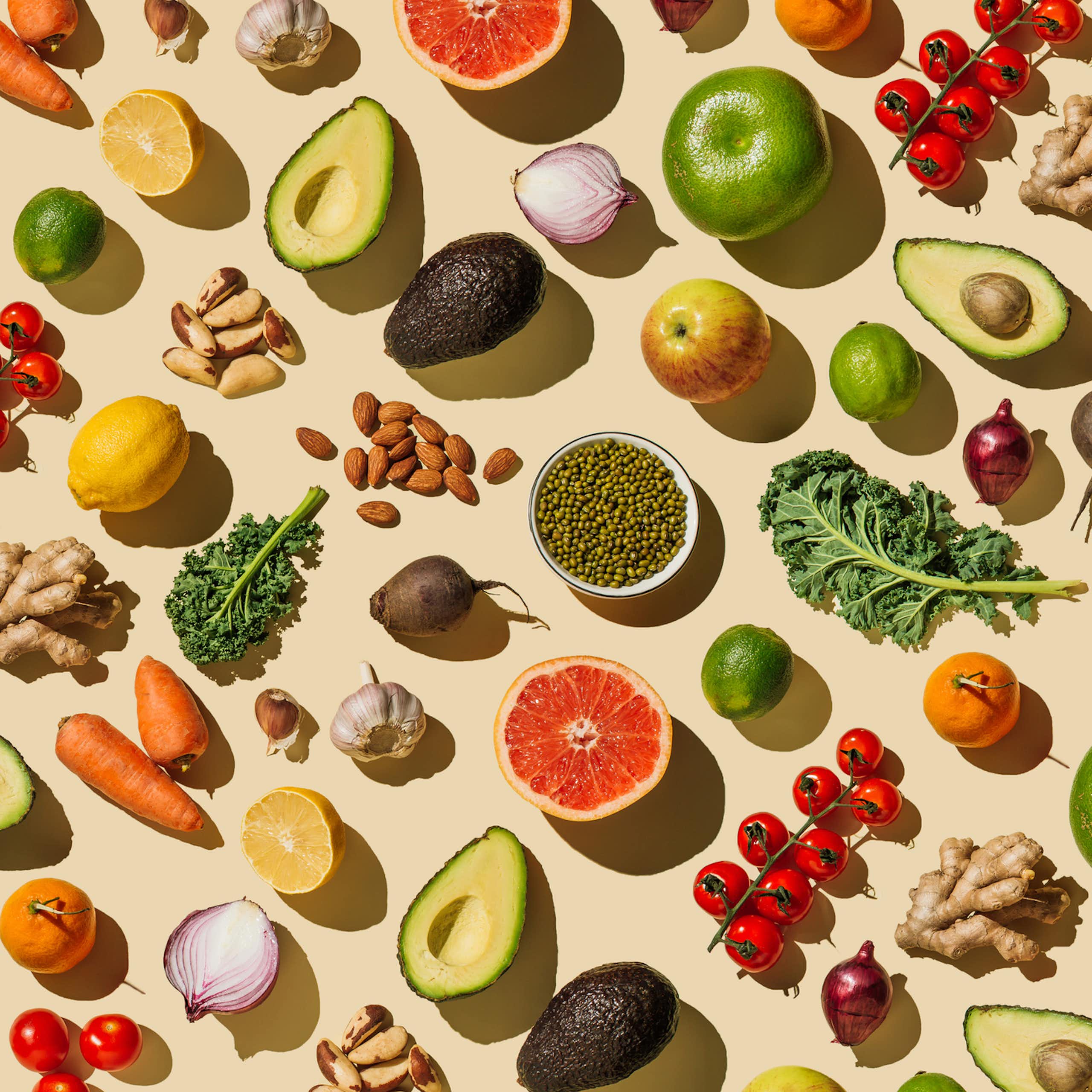 Fruits and vegetables arrayed against a beige background
