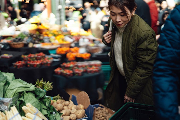 Person looking at vegetables in farmers market