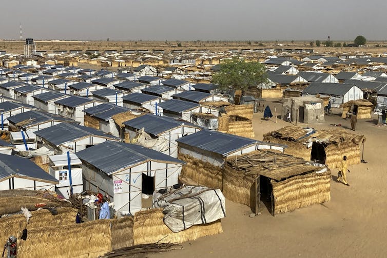 An aerial photograph of temporary shelters set up in the middle of a desert.