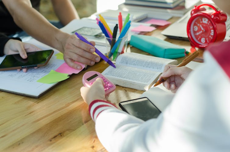 A desk with pencils, books and calculators.