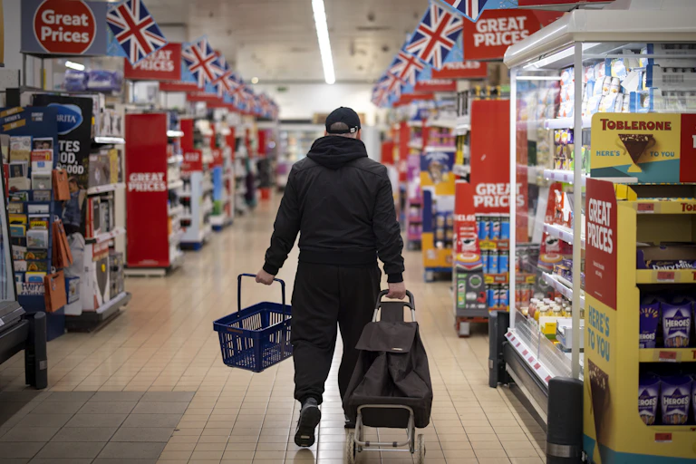 Man shopping in a supermarket aisle with lots of price reductions