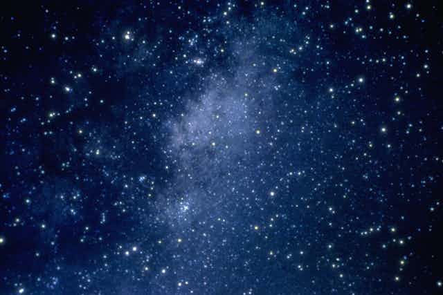 A myriad of stars dot a dark blue outer space