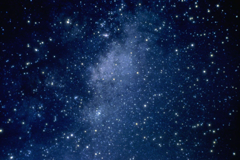 A myriad of stars dot a dark blue outer space