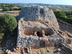 Una construcción de piedra redonda con otra construcción cuadrada adyacente.