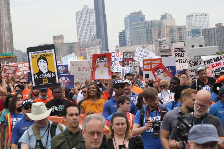 A group of people carrying placards about reforming gun laws.