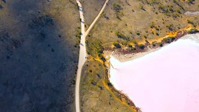 An aerial view of a lake and road in remote Australia.