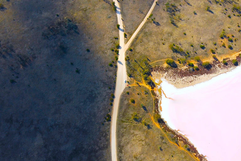 An aerial view of a lake and road in remote Australia.