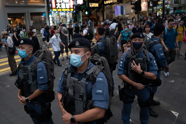 Hong Kong police wearing COVID masks stand guard to prevent a pro-democracy vigil in the centre of Hong Kong June 4 2023.