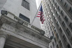 A tall grey stone building with an American flag.