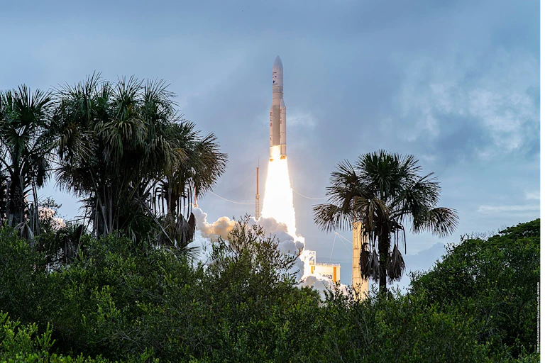 décolage d'ariane 5avec des palmiers au premier plan