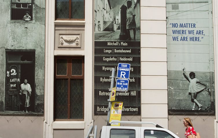 A woman walks past displays outside a museum.