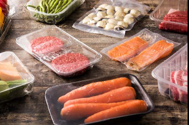 Carne, salmón y verduras en diferentes envases de plástico.