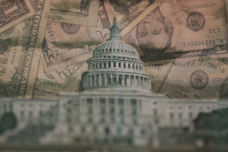 photo collage of US capital building with US currency behind it