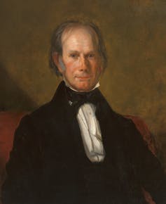 A vintage portrait of an older man with receding brown hair, in a black coat with a white shirt.