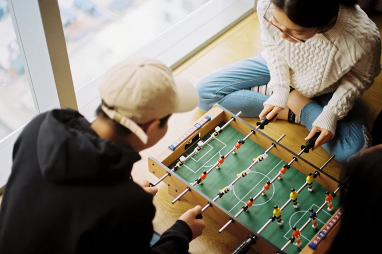 A photo of two people playing foosball