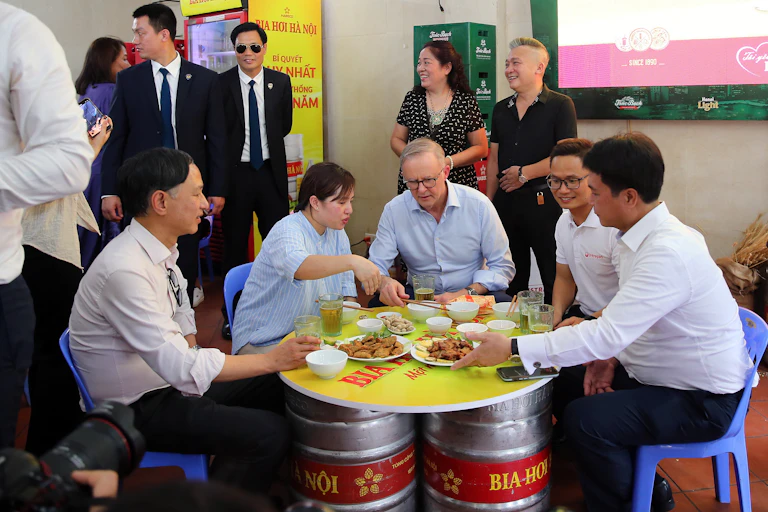 picture of prime minister Anthony Albanese having food and beer in a restaurant in Vietnam