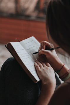 A woman writes in a journal.