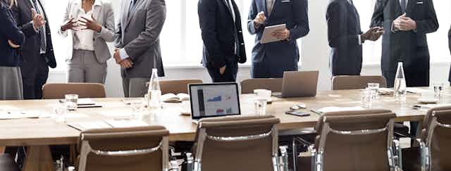 Businesspeople standing around meeting table