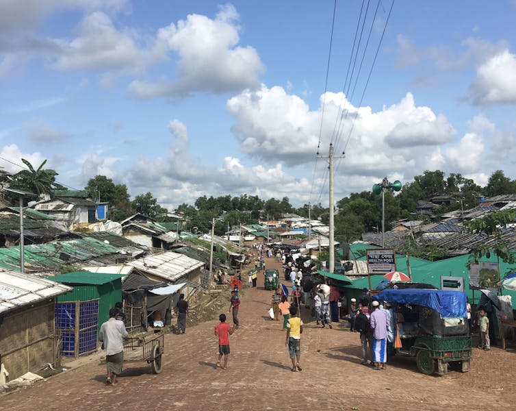 Shanty houses are seen against a blue sky.