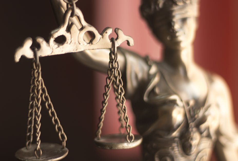 Close up of a golden statuette holding scales of justice