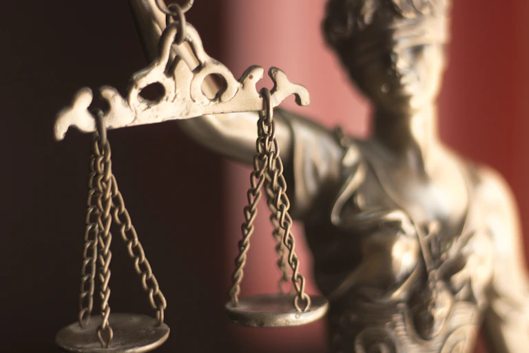 Close up of a golden statuette holding scales of justice