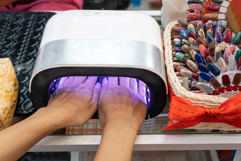 a pair of hands in a square device with purple lights on the inside