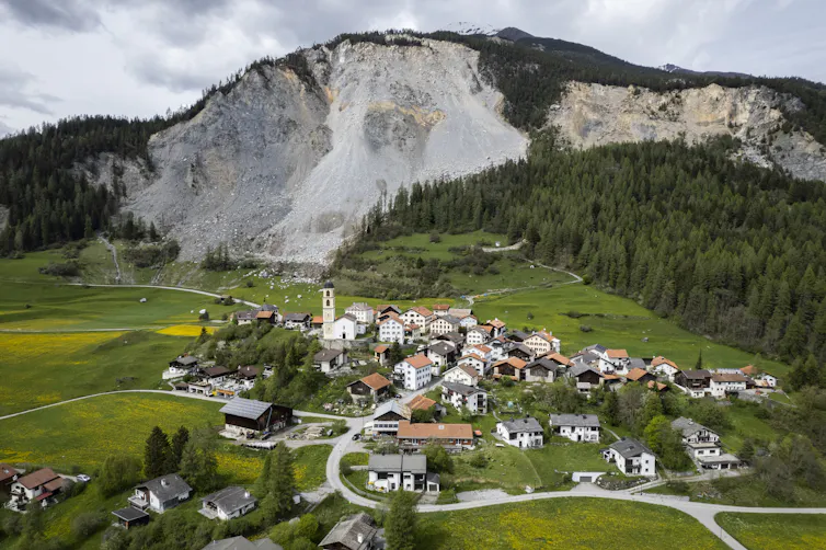 Swiss village below large cliff