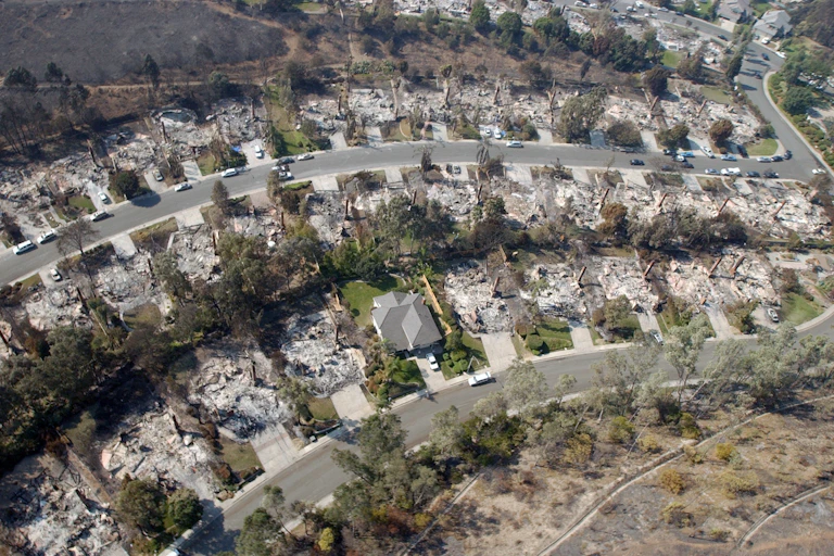 Dozens of burned homes lines a curving street in California. Only one house is still standing.