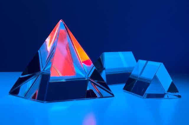 3D illustration of several crystal pyramids on a blue background