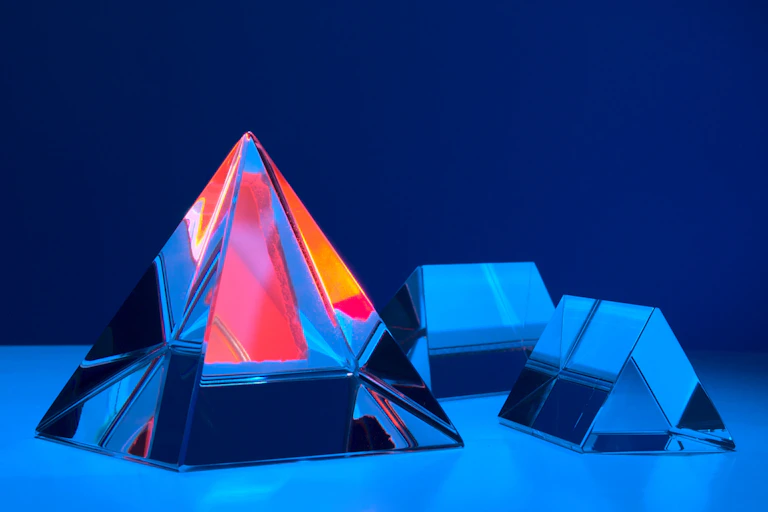 3D illustration of several crystal pyramids on a blue background