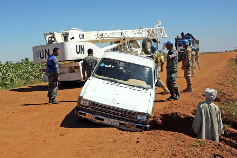 A UN truck stops to help a car in trouble in Dafur, Sudan in 2019.