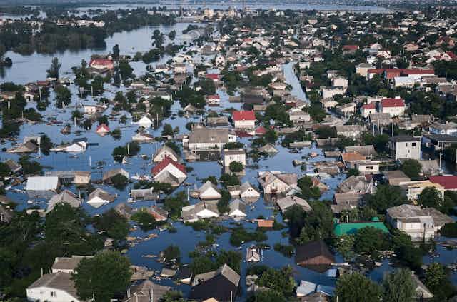 A flooded village photographed from above. Water is up the the rooftops of many buildings.