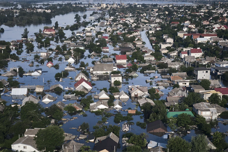 A flooded village photographed from above. Water is up the the rooftops of many buildings.
