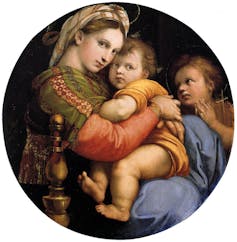 Una mujer sentada abraza a un niño pequeño que tiene en el regazo ante la mirada de otro niño.