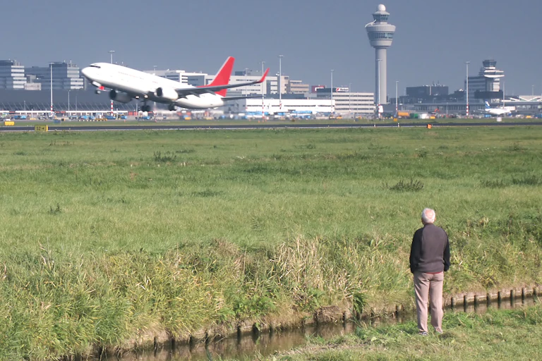 Une personne âgée regarde un avion décoller.
