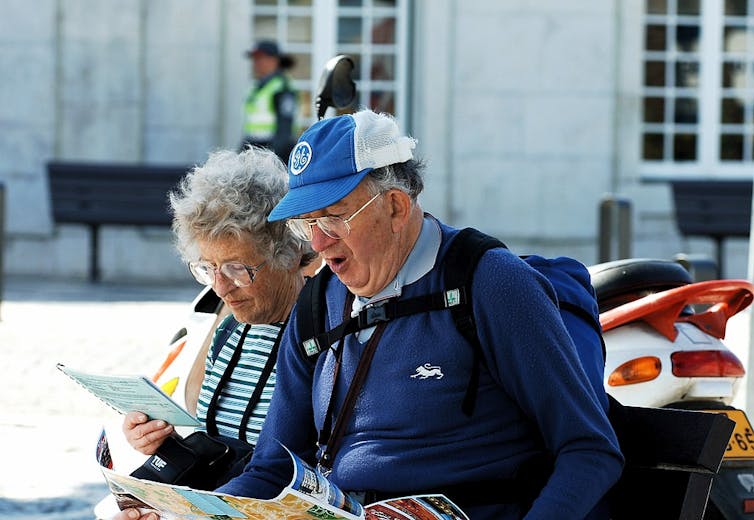 Couple de personnes âgées regardant une carte