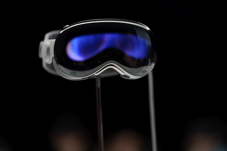 A pair of thick goggles with blue-purple tinted glass displayed on a stand.